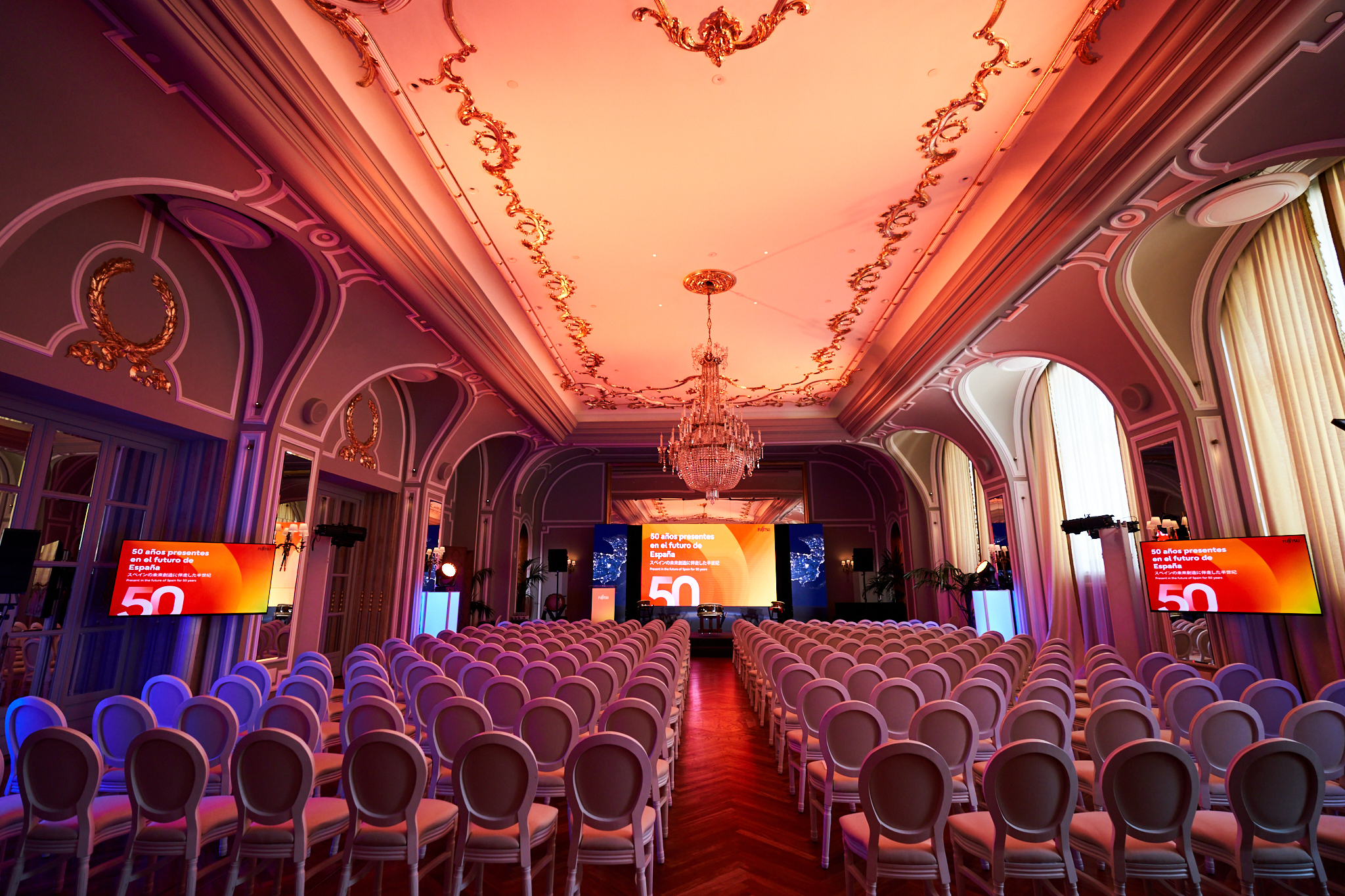 Fotógrafo profesional en Madrid cubriendo la gala del 50 Aniversario de Fujitsu. Vista general de un salón de lujo, con filas de sillas vacías y decoración clásica. Ideal para el reportaje de congresos y galas.