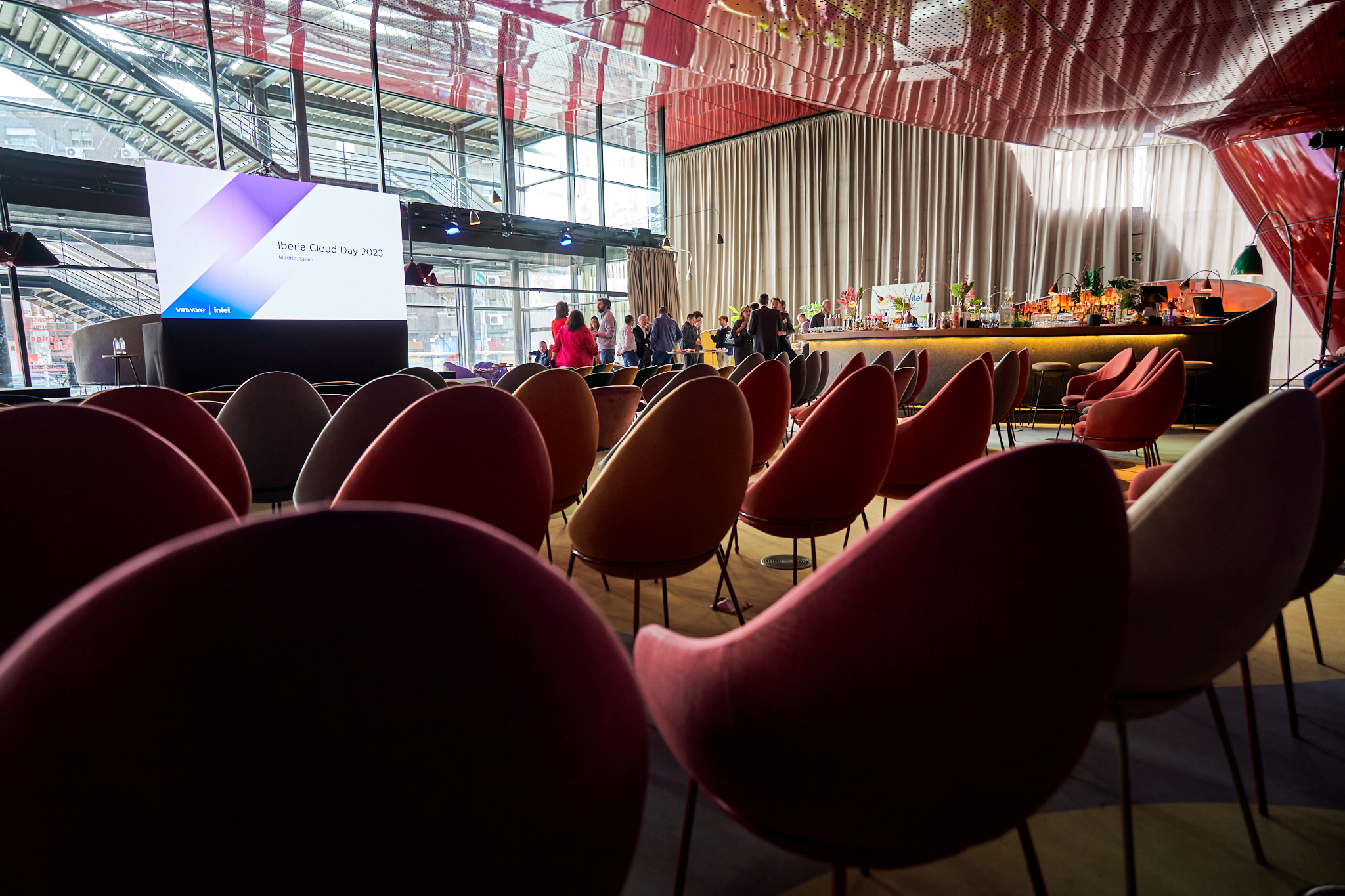 Fotógrafo profesional en Madrid cubriendo el Iberia Cloud Day 2023 o un evento de networking. Muestra una sala con sillas y un bar/barra. Ideal para reportaje de congresos, jornadas y eventos de empresa